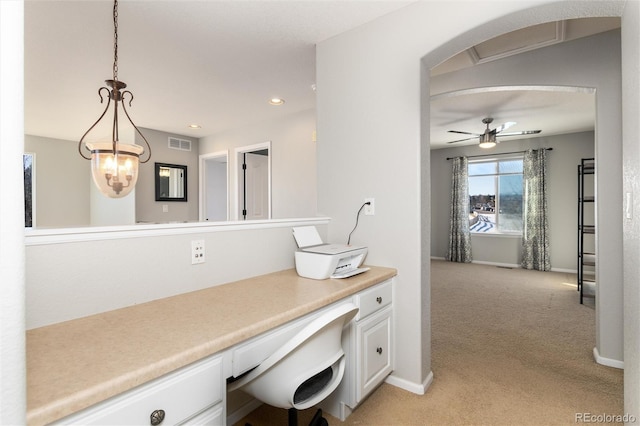 office area with light carpet, ceiling fan, and built in desk