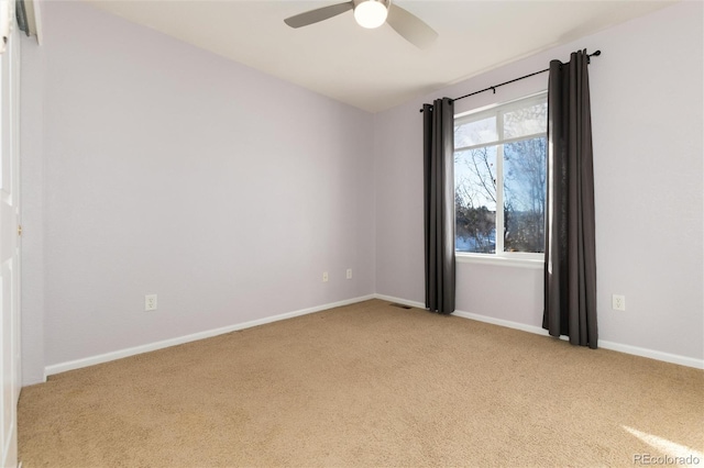 spare room with ceiling fan and light carpet