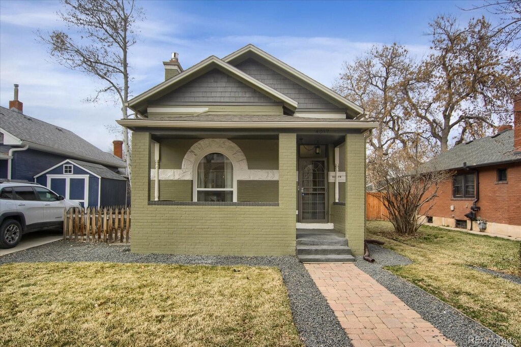 4017 King St, Denver, CO 80211 - bungalow-style home with a front lawn, fence, covered porch, brick siding, and a chimney