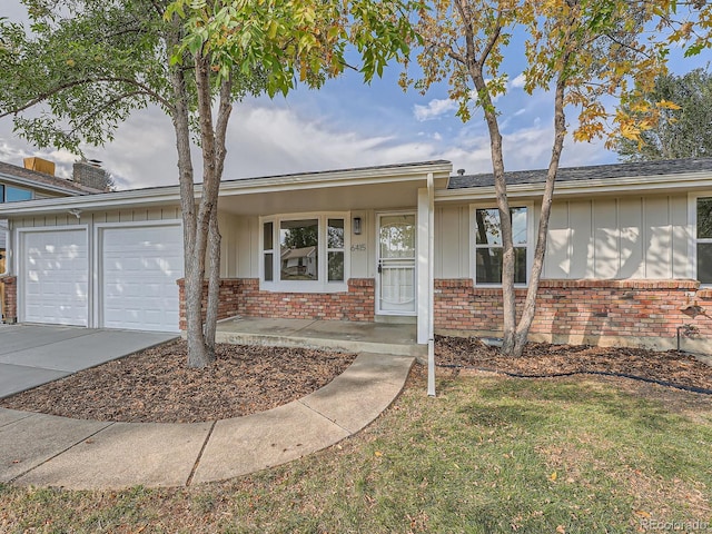 ranch-style house featuring a porch, a front yard, and a garage