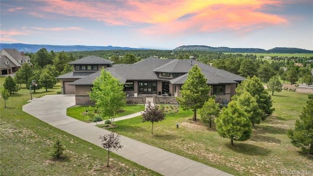 843 Long Timber Ln, Monument, CO 80132 - prairie-style home featuring driveway, a mountain view, a yard, roof with shingles, and stone siding