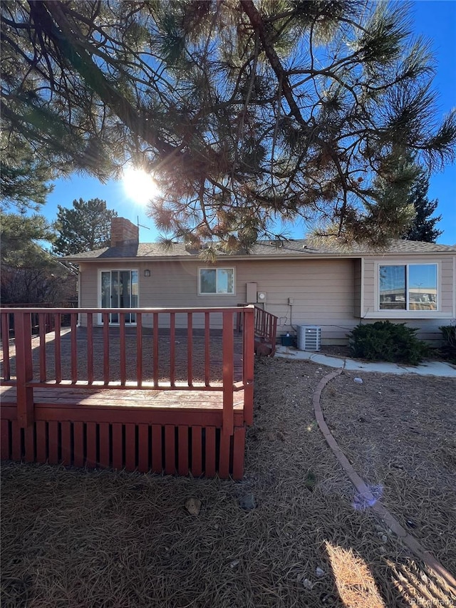 back of house with a deck and central AC unit