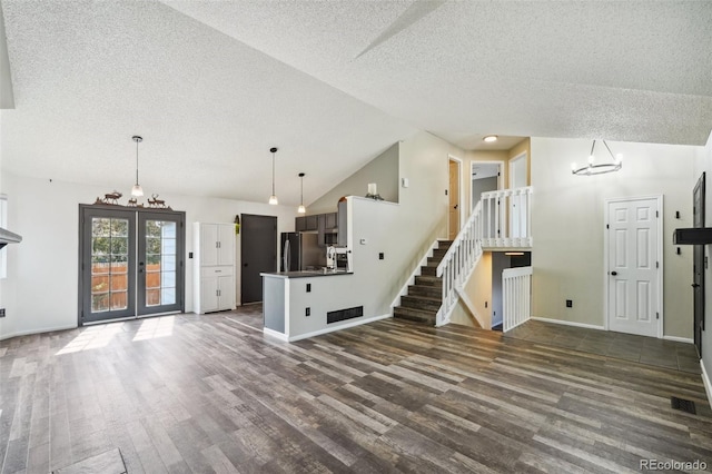 68 N Quicksilver Ave, Castle Rock, CO 80104 - unfurnished living room with a textured ceiling, dark wood-style flooring, baseboards, vaulted ceiling, and stairway