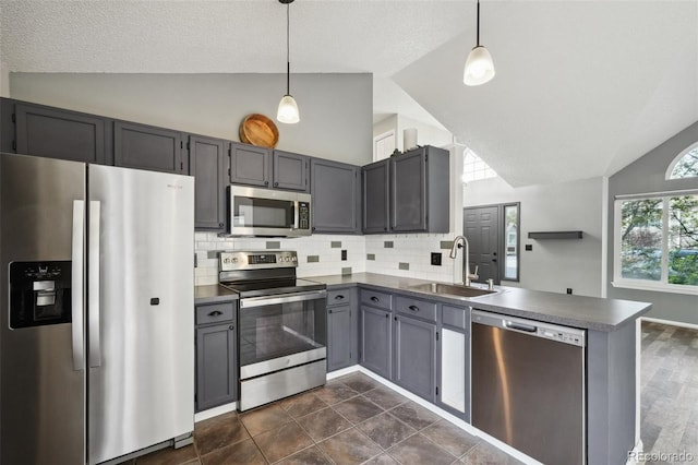 68 N Quicksilver Ave, Castle Rock, CO 80104 - kitchen featuring appliances with stainless steel finishes, a sink, a peninsula, dark countertops, and high vaulted ceiling