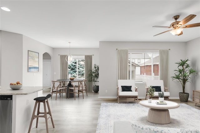 186 S 45th Ave, Brighton, CO 80601 - living room featuring arched walkways, light wood finished floors, and ceiling fan