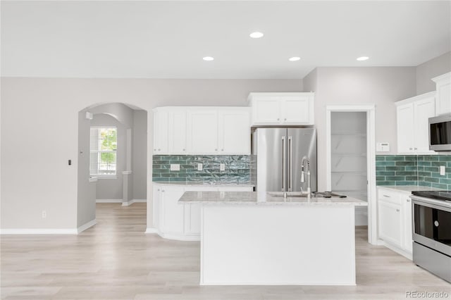 186 S 45th Ave, Brighton, CO 80601 - kitchen with stainless steel appliances, arched walkways, decorative backsplash, white cabinetry, and recessed lighting