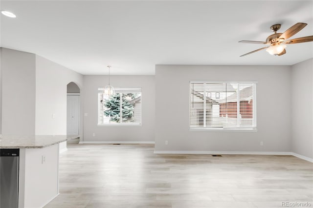 186 S 45th Ave, Brighton, CO 80601 - unfurnished dining area featuring light wood-style floors, arched walkways, a ceiling fan, a chandelier, and recessed lighting