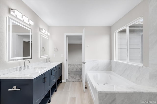186 S 45th Ave, Brighton, CO 80601 - full bathroom with double vanity, a garden tub, and wood finished floors