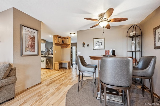 dining area with light wood finished floors, baseboards, and a ceiling fan