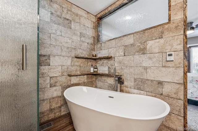 bathroom with a soaking tub and visible vents