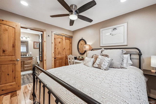 bedroom with light wood finished floors, recessed lighting, a closet, ceiling fan, and ensuite bath