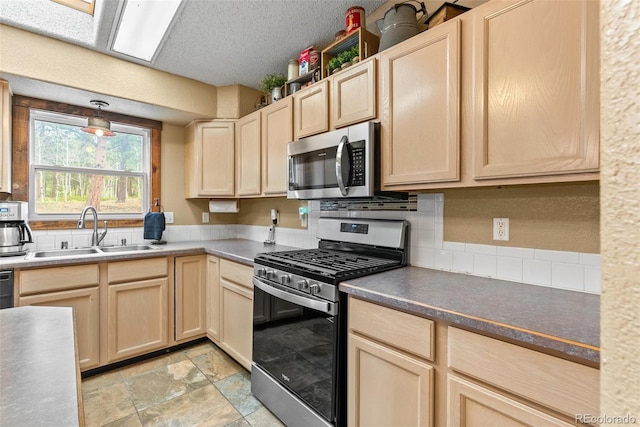 50 Rd P78, Bailey, CO 80421 - kitchen with stainless steel appliances, a sink, light brown cabinetry, tasteful backsplash, and light stone finish floors