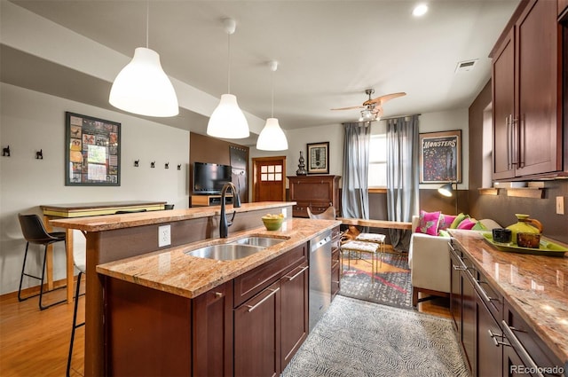 469 Elati St, Denver, CO 80204 - kitchen featuring a breakfast bar, a sink, dishwasher, wood finished floors, and visible vents