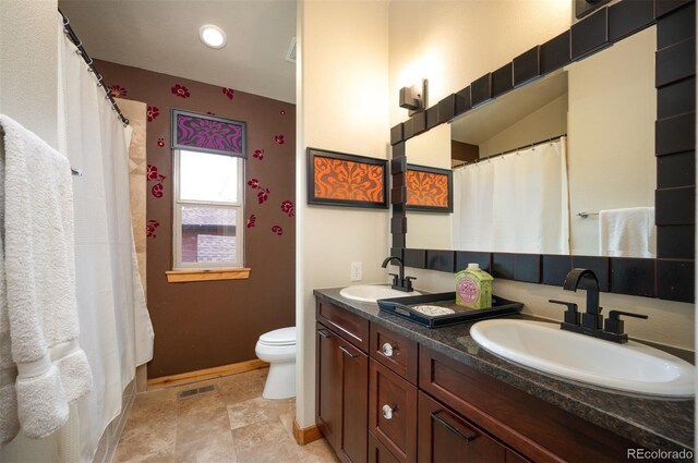 469 Elati St, Denver, CO 80204 - bathroom featuring baseboards, a sink, double vanity, and toilet