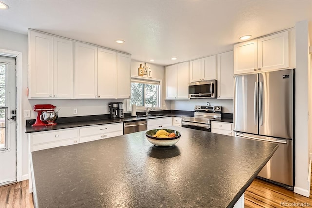 2034 S Idalia St, Aurora, CO 80013 - kitchen with stainless steel appliances, dark countertops, a sink, recessed lighting, and white cabinets
