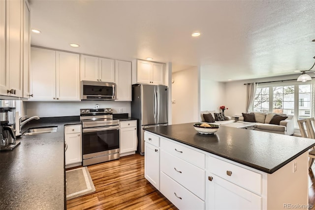 2034 S Idalia St, Aurora, CO 80013 - kitchen featuring appliances with stainless steel finishes, a sink, dark countertops, white cabinets, and recessed lighting