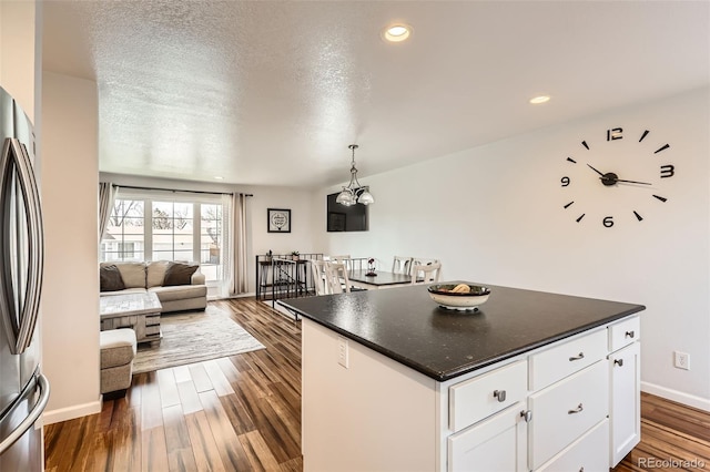 2034 S Idalia St, Aurora, CO 80013 - kitchen with freestanding refrigerator, white cabinetry, dark countertops, open floor plan, and dark wood-style flooring