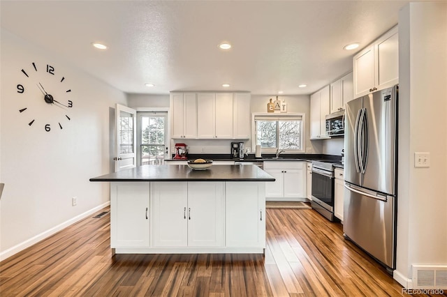 2034 S Idalia St, Aurora, CO 80013 - kitchen featuring stainless steel appliances, dark countertops, a sink, plenty of natural light, and recessed lighting