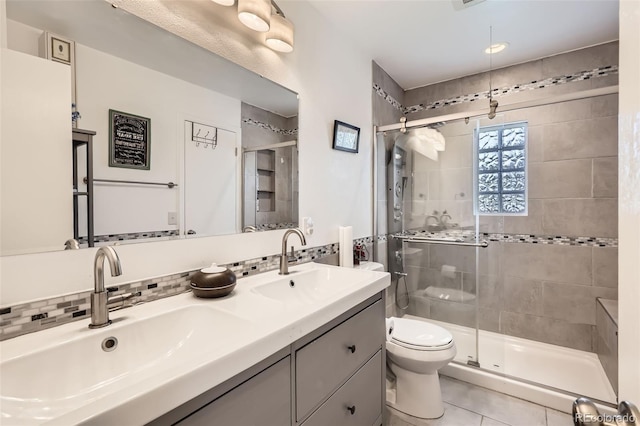 2034 S Idalia St, Aurora, CO 80013 - full bathroom featuring toilet, a shower stall, double vanity, tile patterned flooring, and decorative backsplash