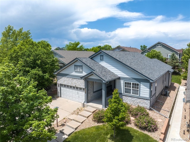23421 E Long Pl, Aurora, CO 80016 - view of front facade featuring a shingled roof, concrete driveway, covered porch, an attached garage, and stone siding