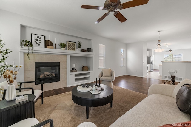 23421 E Long Pl, Aurora, CO 80016 - living area with wood finished floors, ceiling fan, built in features, and a fireplace