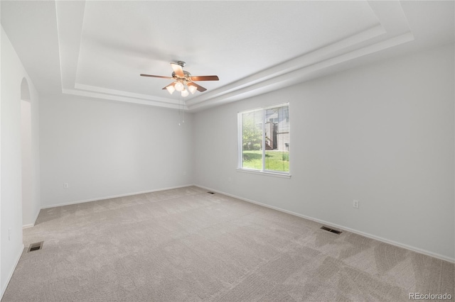 23421 E Long Pl, Aurora, CO 80016 - unfurnished room with a tray ceiling, ceiling fan, light colored carpet, and arched walkways