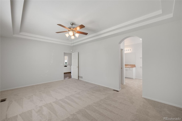23421 E Long Pl, Aurora, CO 80016 - empty room with a raised ceiling, arched walkways, a ceiling fan, and light carpet