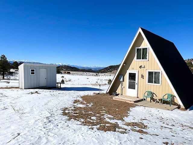 exterior space with a mountain view and a storage shed