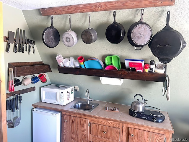 kitchen with sink, refrigerator, and tile counters