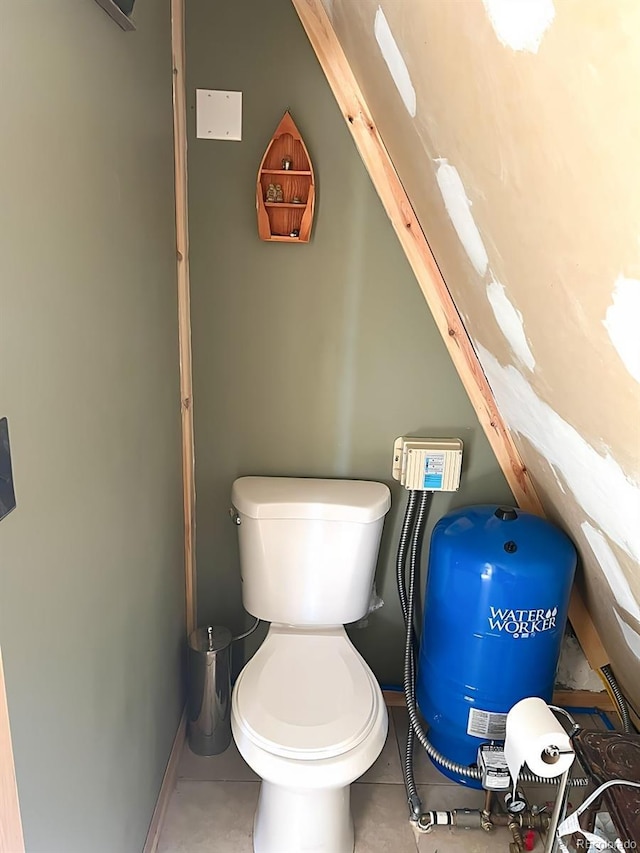 bathroom with toilet, lofted ceiling, and tile patterned flooring