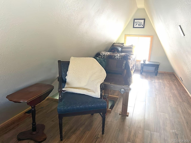 living area featuring hardwood / wood-style floors, a textured ceiling, and lofted ceiling