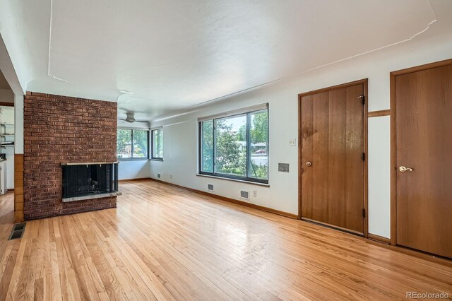 5600 Dover St, Arvada, CO 80002 - unfurnished living room with a fireplace, light wood finished floors, ceiling fan, and baseboards