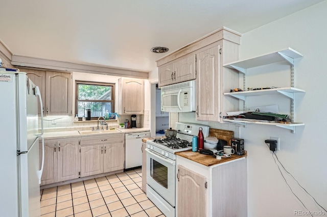 5600 Dover St, Arvada, CO 80002 - kitchen with white appliances, a sink, backsplash, light countertops, and light tile patterned floors