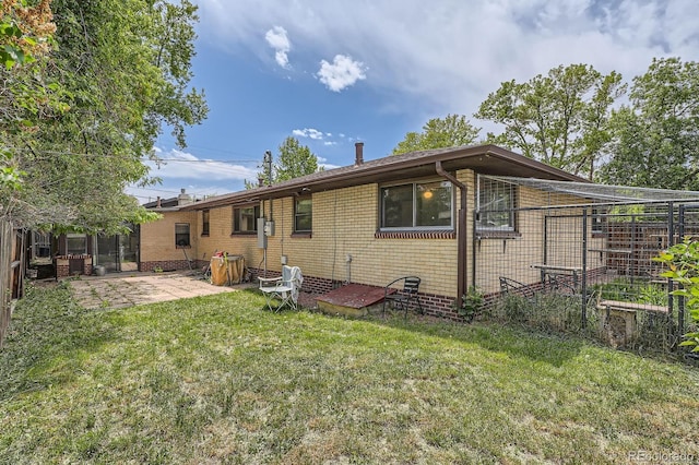 5600 Dover St, Arvada, CO 80002 - rear view of house featuring a patio area, a yard, and brick siding