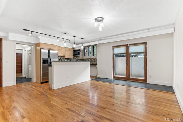 kitchen with tasteful backsplash, dark countertops, light wood-style flooring, french doors, and stainless steel appliances