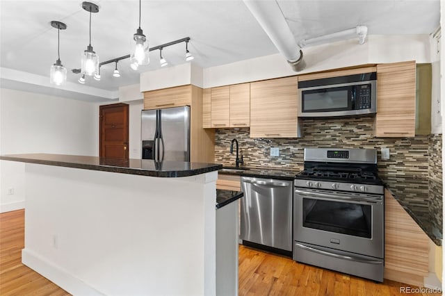 kitchen featuring dark countertops, decorative backsplash, appliances with stainless steel finishes, and a kitchen island