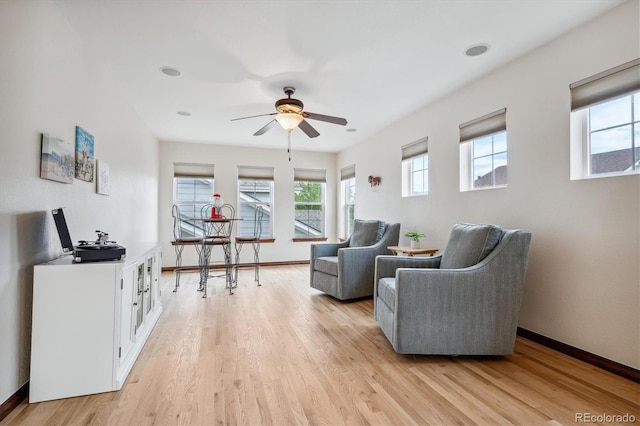 living room featuring ceiling fan and light hardwood / wood-style flooring