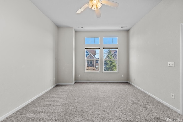 carpeted empty room featuring visible vents, baseboards, and a ceiling fan