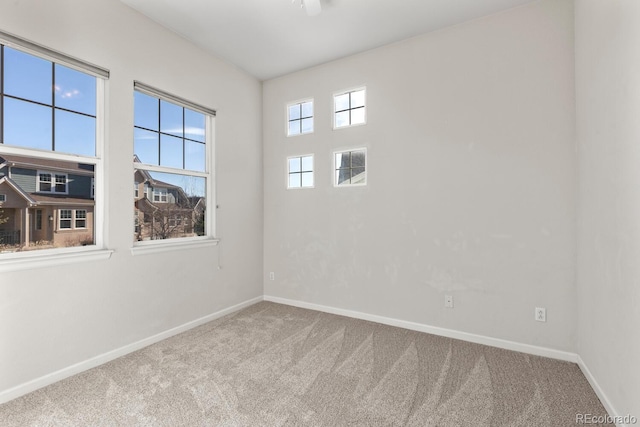 carpeted spare room featuring baseboards