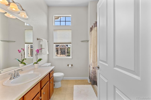 bathroom featuring plenty of natural light, toilet, vanity, and tile patterned flooring