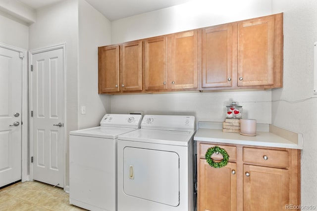 washroom featuring washer and clothes dryer, light tile patterned floors, and cabinet space