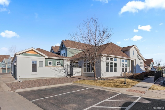 view of front of property with stucco siding, a residential view, and uncovered parking