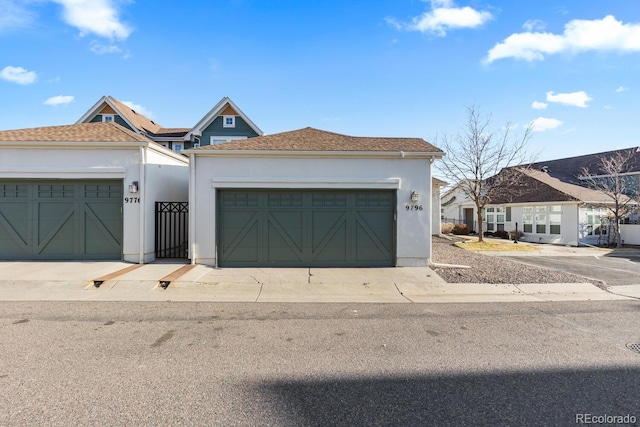 view of front facade with a garage, driveway, and stucco siding