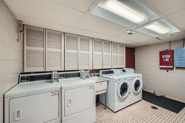 1045 N Pennsylvania St Unit 601, Denver, CO 80203 - shared laundry with washing machine and clothes dryer, concrete block wall, light tile patterned floors, and electric panel