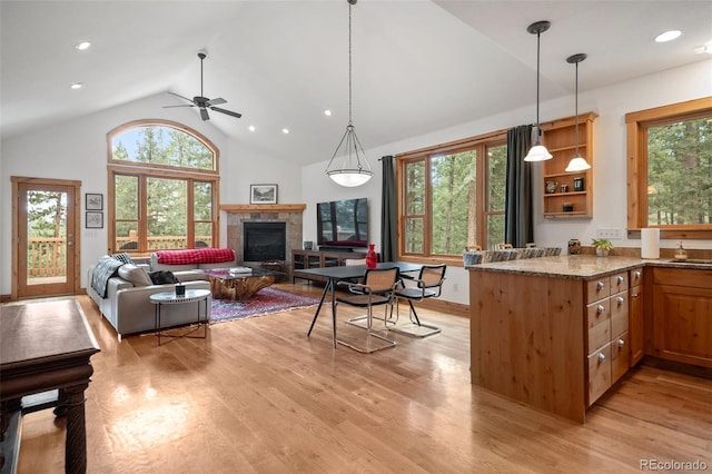 27711 Moffat Rd, Evergreen, CO 80439 - kitchen featuring plenty of natural light, a ceiling fan, light wood-style floors, and a glass covered fireplace