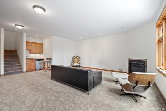 27711 Moffat Rd, Evergreen, CO 80439 - living area featuring light colored carpet, a glass covered fireplace, stairs, baseboards, and visible vents