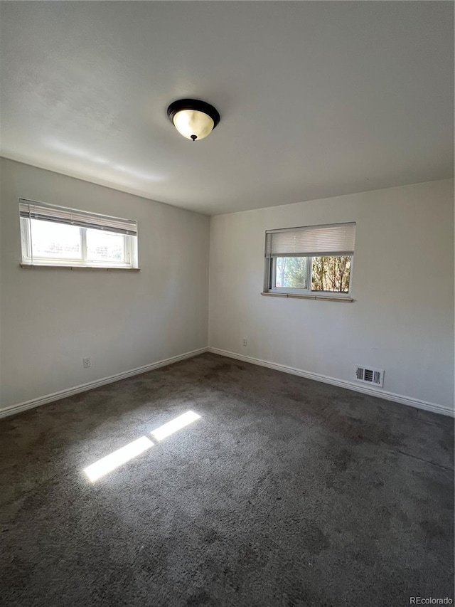 empty room featuring dark carpet