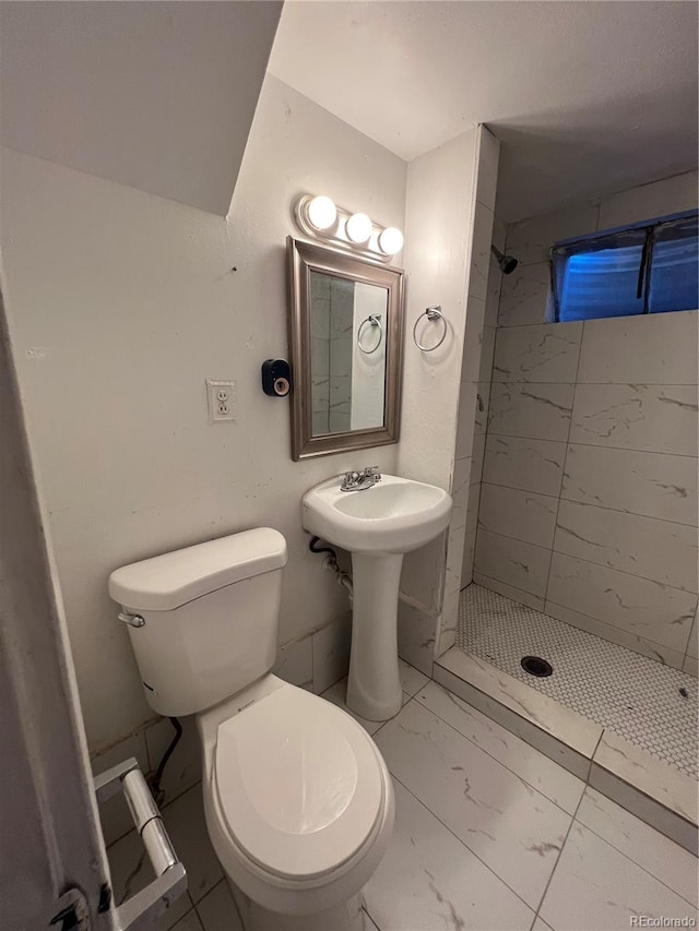 bathroom featuring tiled shower and toilet