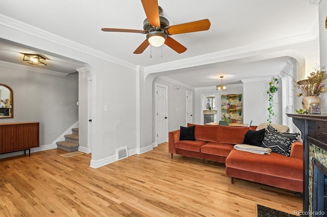 living room featuring crown molding, light hardwood / wood-style flooring, and ceiling fan