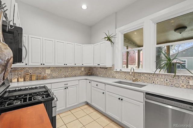 kitchen featuring tasteful backsplash, white cabinetry, appliances with stainless steel finishes, and sink